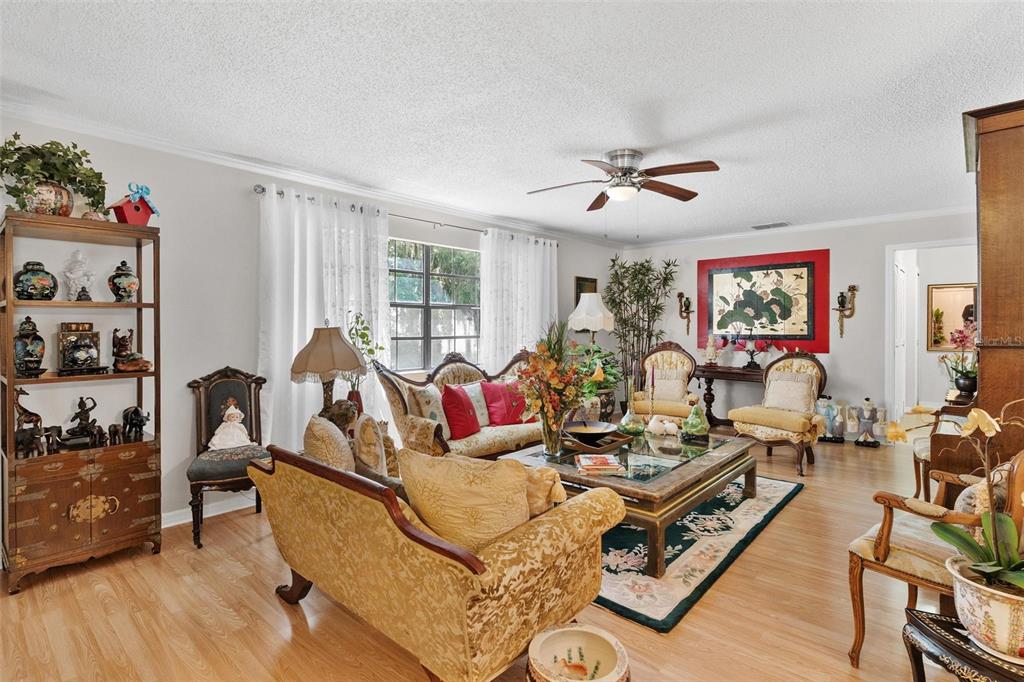 A living room features traditional furniture, a glass coffee table, and light wood flooring — 500 NEWELL HILL ROAD UNIT 108D, LEESBURG, FL