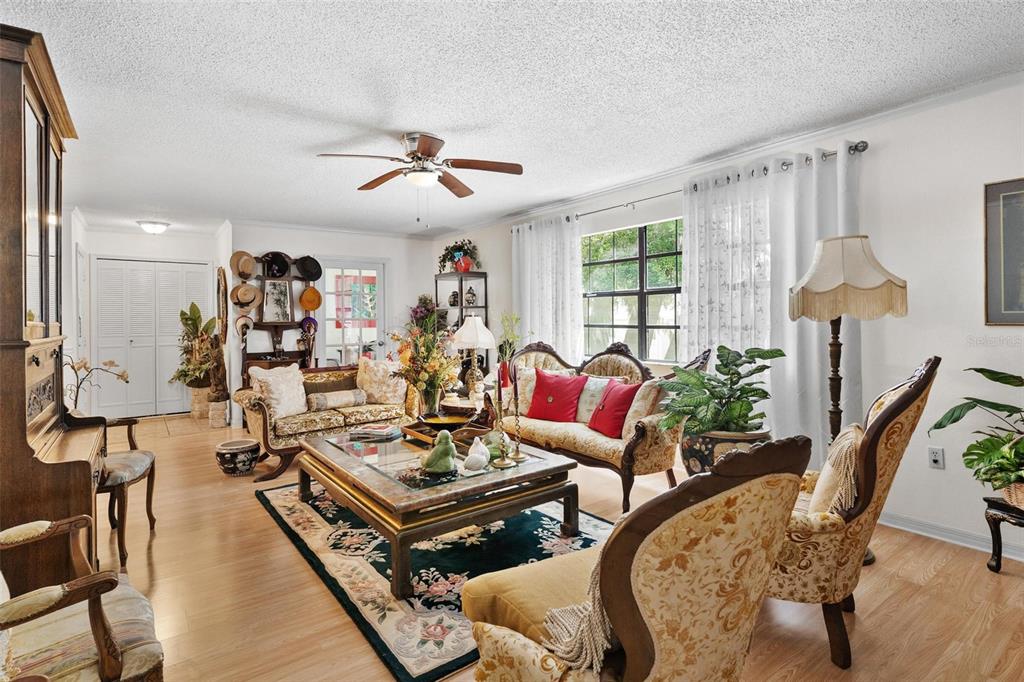 A living room features traditional furniture, a central coffee table, and a ceiling fan — 500 NEWELL HILL ROAD UNIT 108D, LEESBURG, FL