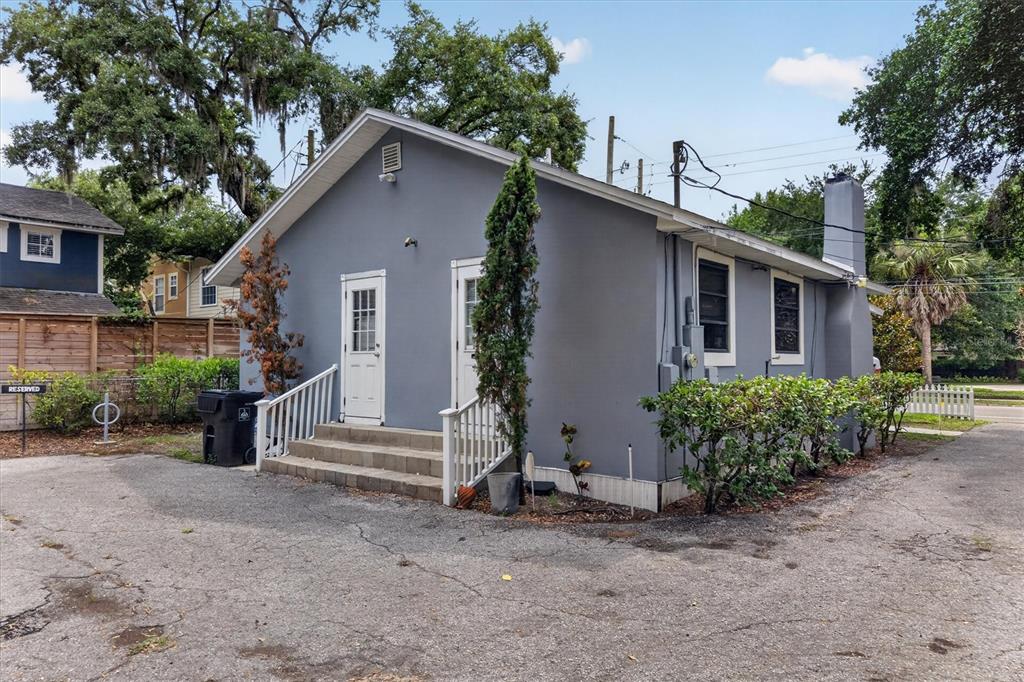 A gray, single-story building with two white doors, a concrete staircase, and a paved parking area — 813 N FERN CREEK AVENUE, ORLANDO, FL