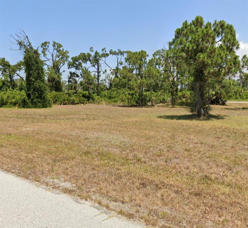A vacant, grassy lot with scattered pine trees under a clear blue sky — 14 RUDDER LANE, PLACIDA, FL