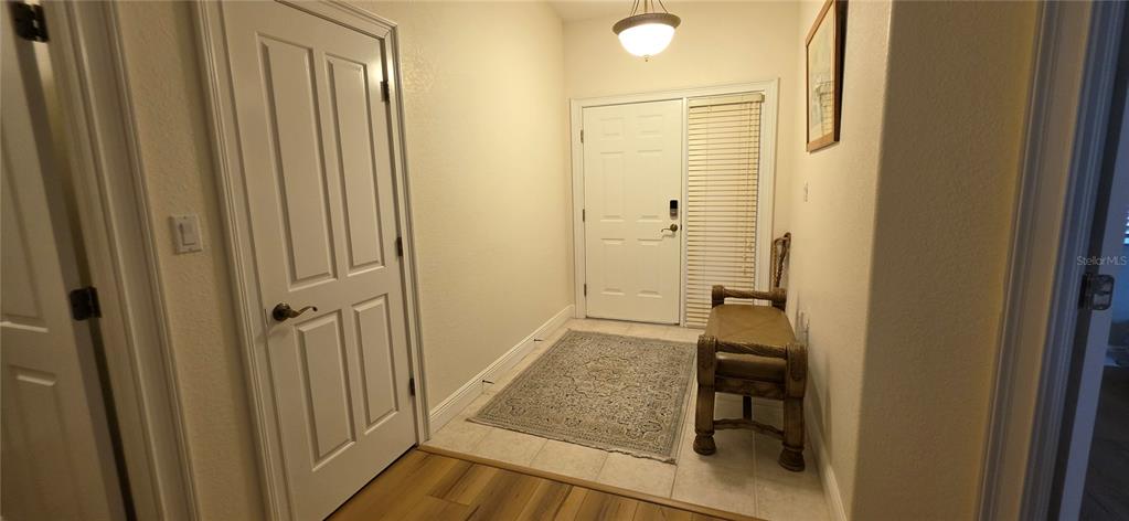 An entryway features a white front door, a patterned area rug, and a wooden bench — 222 LEWIS CIRCLE UNIT 142, PUNTA GORDA, FL