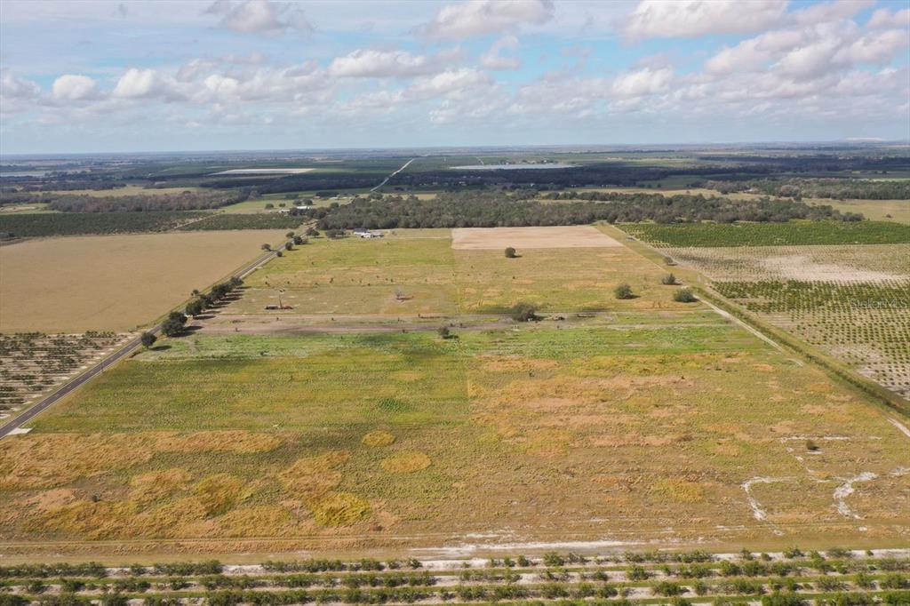 An aerial view of a large, flat, grassy field surrounded by trees and agricultural land — LOT 11 LAKE BUFFUM ROAD S, FORT MEADE, FL