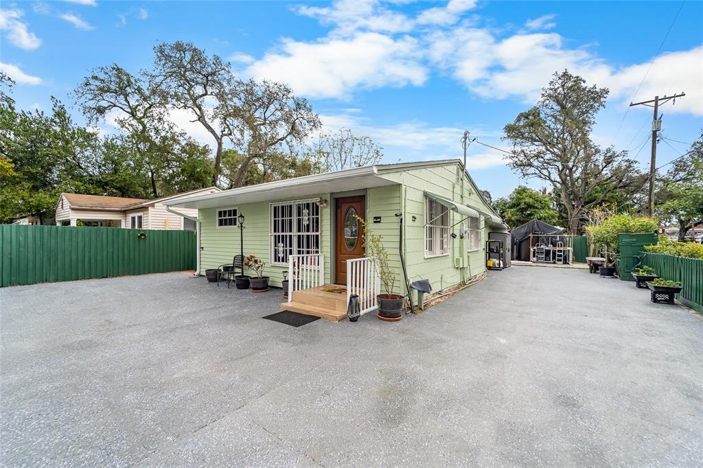A light green house with a front porch and a large paved driveway — 10001 N ARDEN AVENUE, TAMPA, FL