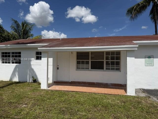 A white, single-story house features a covered front porch and a reddish-brown shingled roof — 2115 SW 50th Ave, West Park FL 33023, WEST PARK, FL