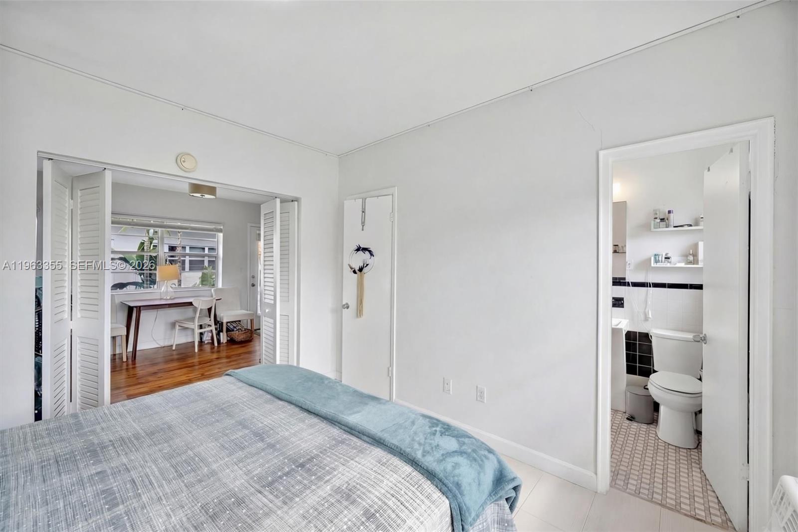 A bedroom with a bed, an adjacent office space, and an attached bathroom — 1925 Washington Ave # 21, Miami Beach FL 33139, MIAMI BEACH, FL