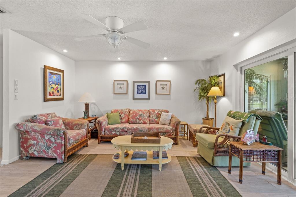 A living room features floral furniture, a coffee table, and a ceiling fan on tile floors — 140 ASHLEY LANE, OLDSMAR, FL