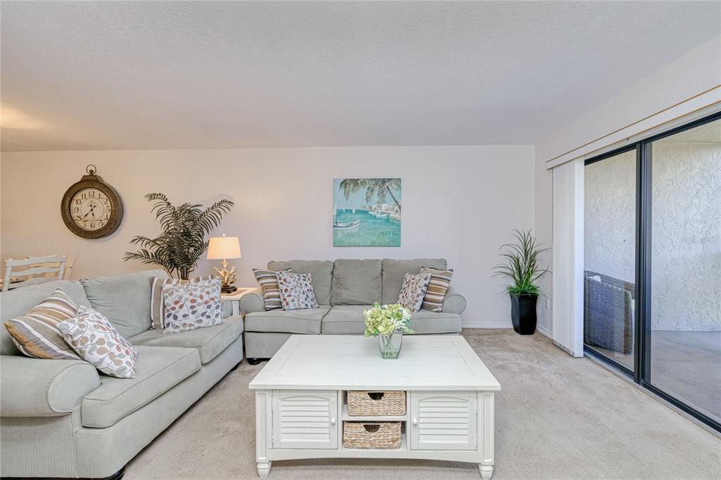 A living room features light-colored sofas, a white coffee table, and a sliding glass door — 175 KINGS HIGHWAY UNIT 225 (B5), PUNTA GORDA, FL