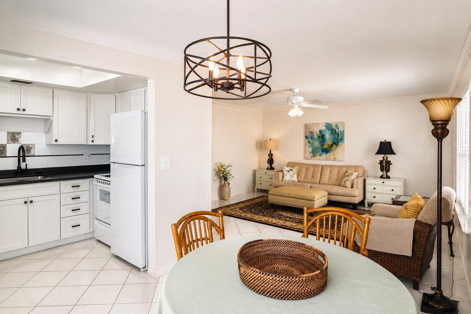 A kitchen with white cabinets and a dining area opening into a living room — 2929 SE Ocean Boulevard # 10, Stuart FL 34996, STUART, FL