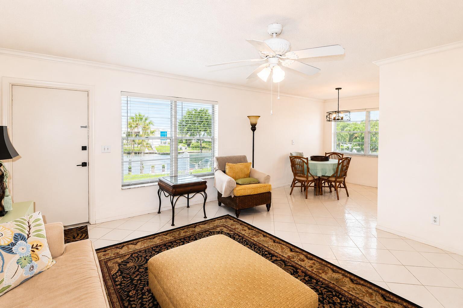 An open-concept living and dining area features tile flooring, a ceiling fan, and waterfront views — 2929 SE Ocean Boulevard # 10, Stuart FL 34996, STUART, FL