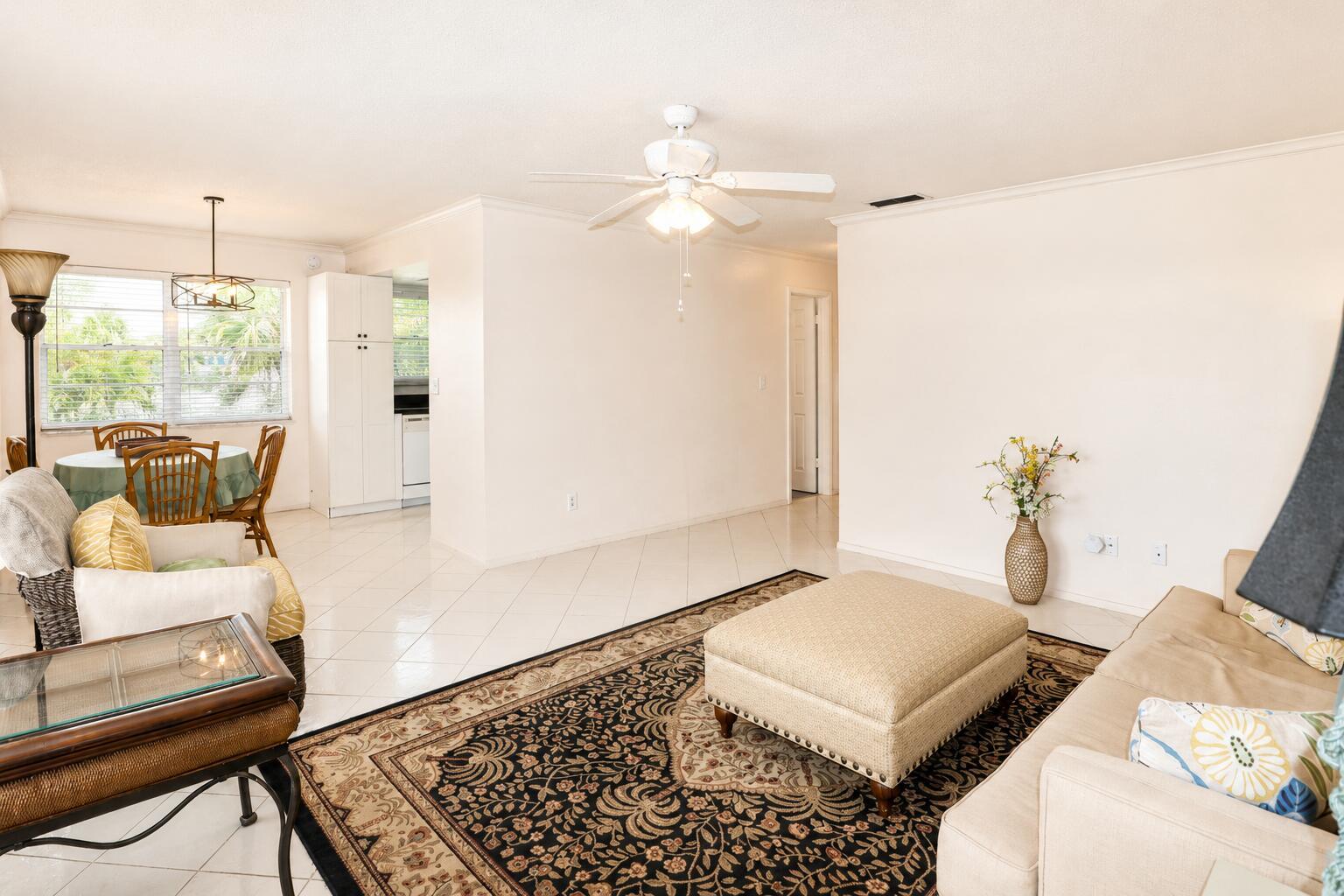 A living room with tile floors, a patterned area rug, and an adjacent dining area — 2929 SE Ocean Boulevard # 10, Stuart FL 34996, STUART, FL