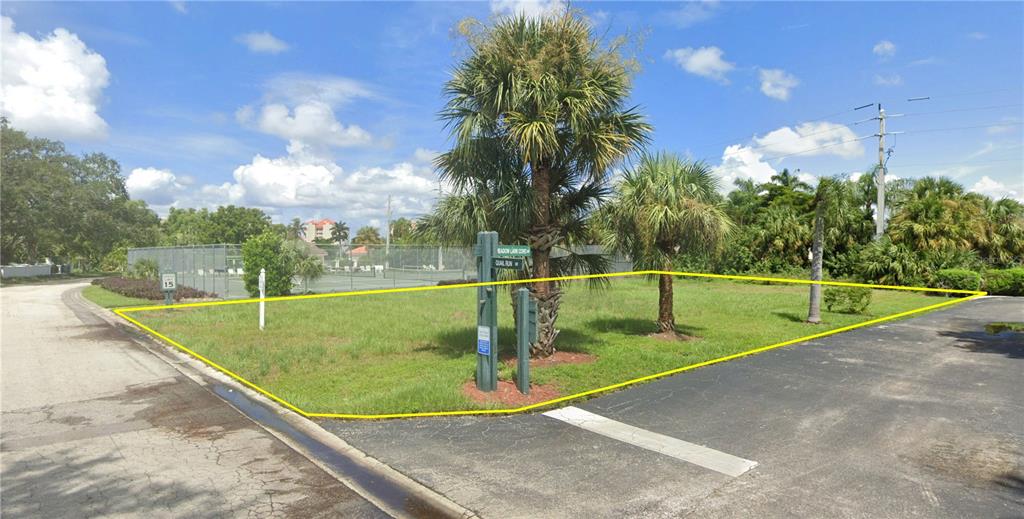 A vacant, grassy residential lot is outlined in yellow next to a paved road — 11954 QUAIL RUN DRIVE, FORT MYERS, FL
