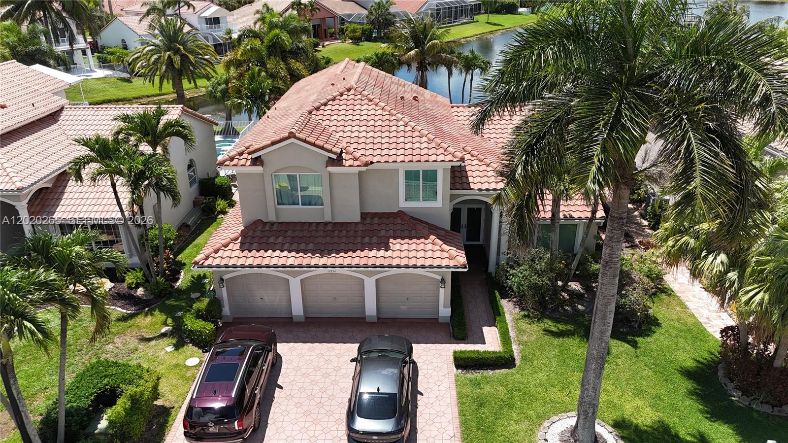 An aerial view shows a two-story house with a tile roof, three-car garage, and driveway — 19432 Preserve Dr, Boca Raton FL 33498, BOCA RATON, FL