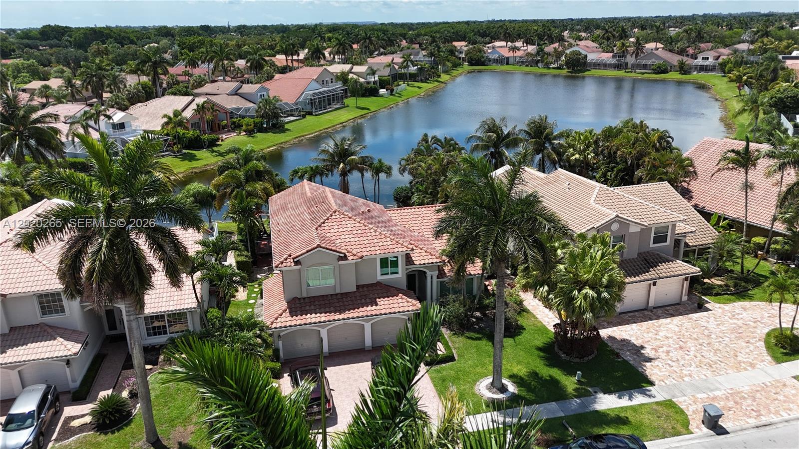 An aerial view shows suburban houses with tile roofs situated along a large lake — 19432 Preserve Dr, Boca Raton FL 33498, BOCA RATON, FL