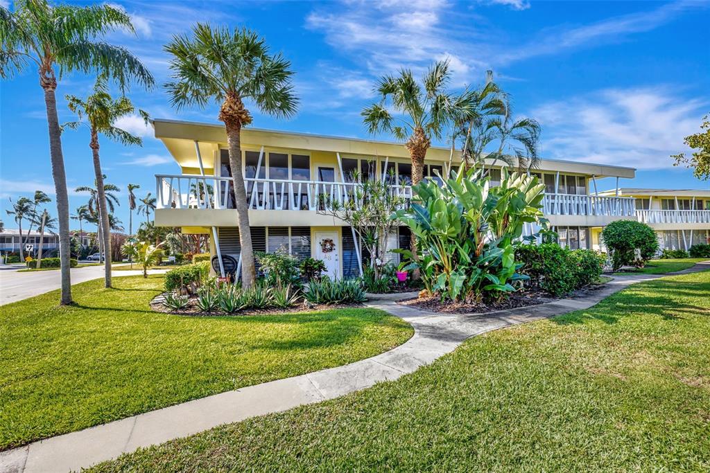 A two-story yellow apartment building with a balcony, palm trees, and a landscaped lawn — 2755 NE 28TH AVENUE UNIT A3, LIGHTHOUSE POINT, FL