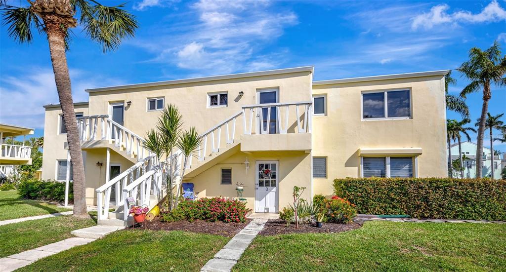 A two-story yellow stucco apartment building features an exterior staircase and a landscaped front yard — 2755 NE 28TH AVENUE UNIT A3, LIGHTHOUSE POINT, FL