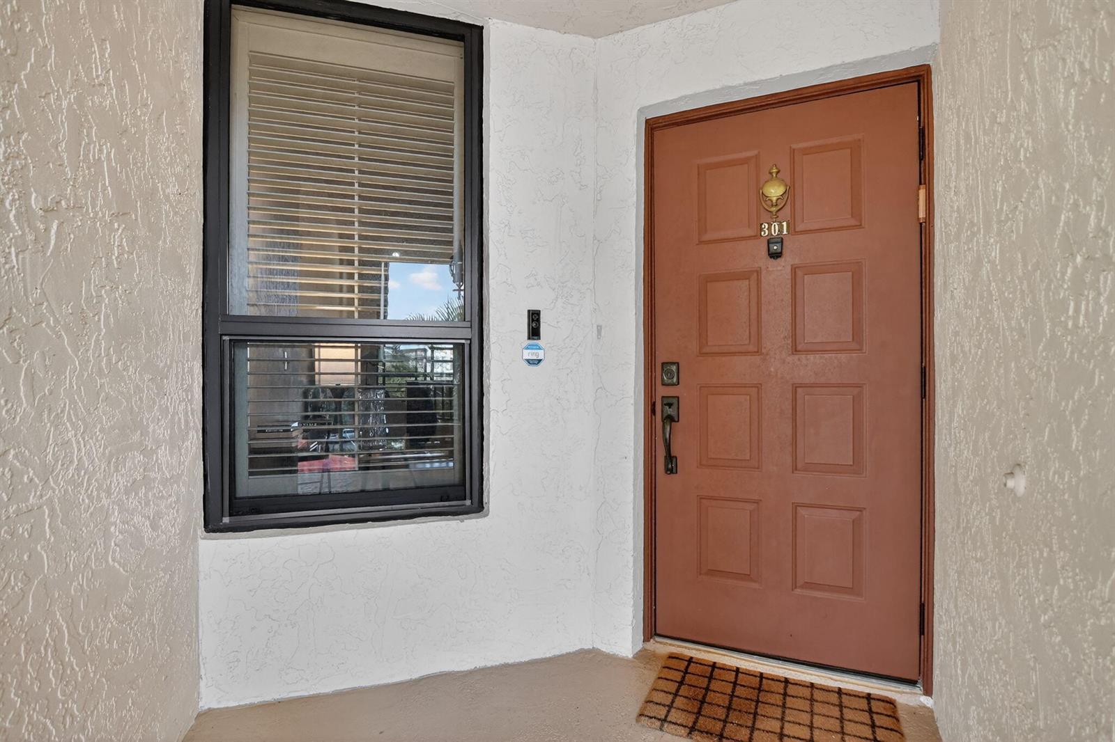 A brown front door with a brass knocker and a window with blinds on a porch — 7535 La Paz Boulevard # 301, Boca Raton FL 33433, BOCA RATON, FL