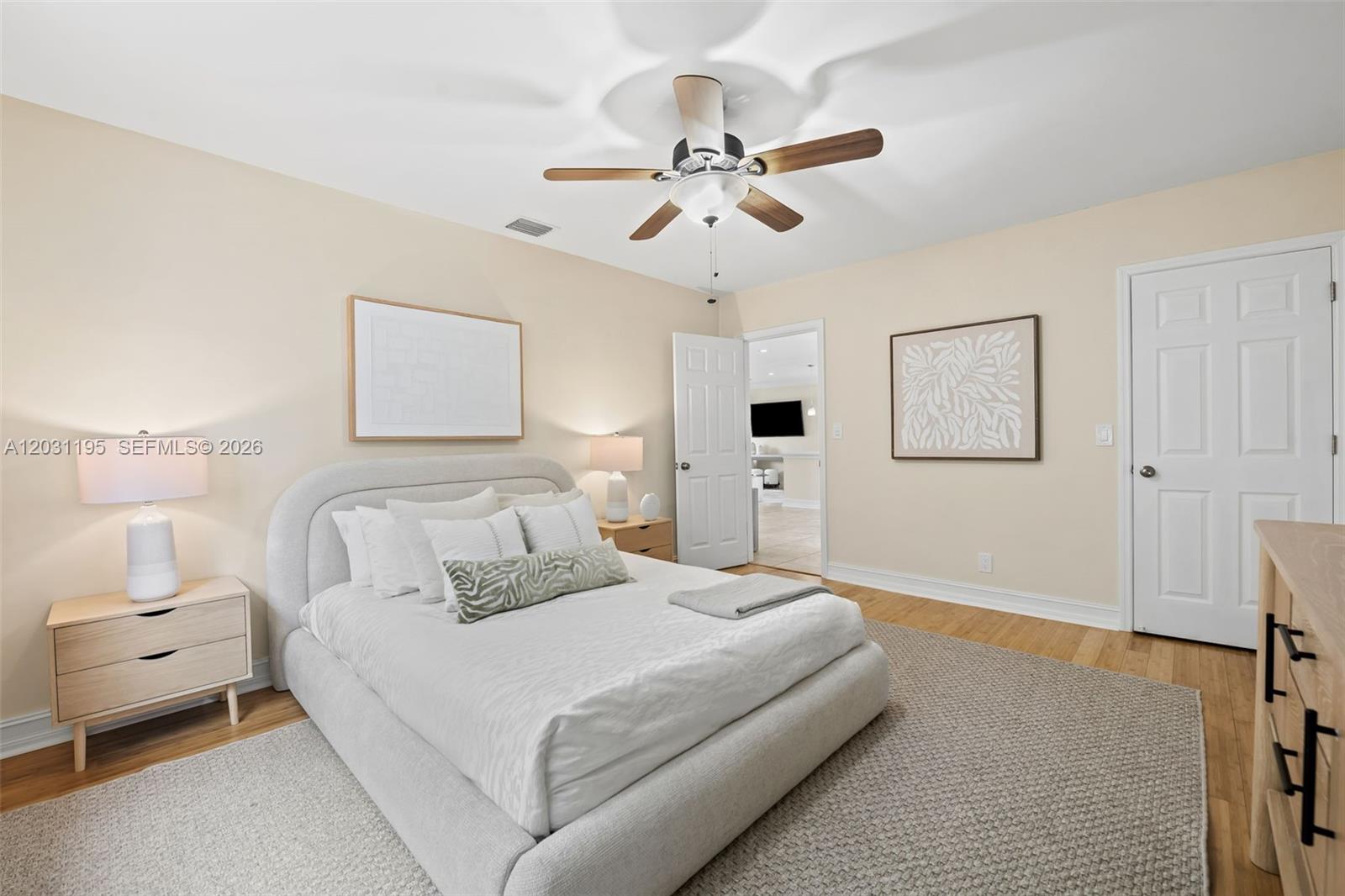 A bedroom features a light-colored upholstered bed, wooden nightstands, and a ceiling fan — 370 SE 12th Ave, Pompano Beach FL 33060, POMPANO BEACH, FL