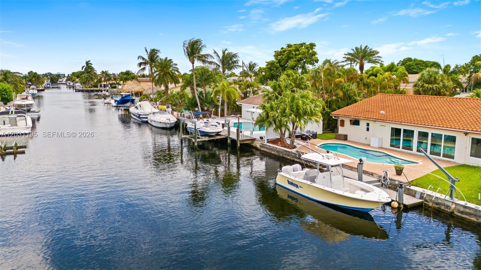 An aerial view shows a canal with multiple boats docked alongside waterfront homes and pools — 370 SE 12th Ave, Pompano Beach FL 33060, POMPANO BEACH, FL