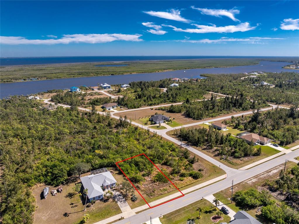 An aerial view shows a vacant, rectangular residential lot outlined in red next to a house — 9346 ST PAUL DRIVE, PORT CHARLOTTE, FL
