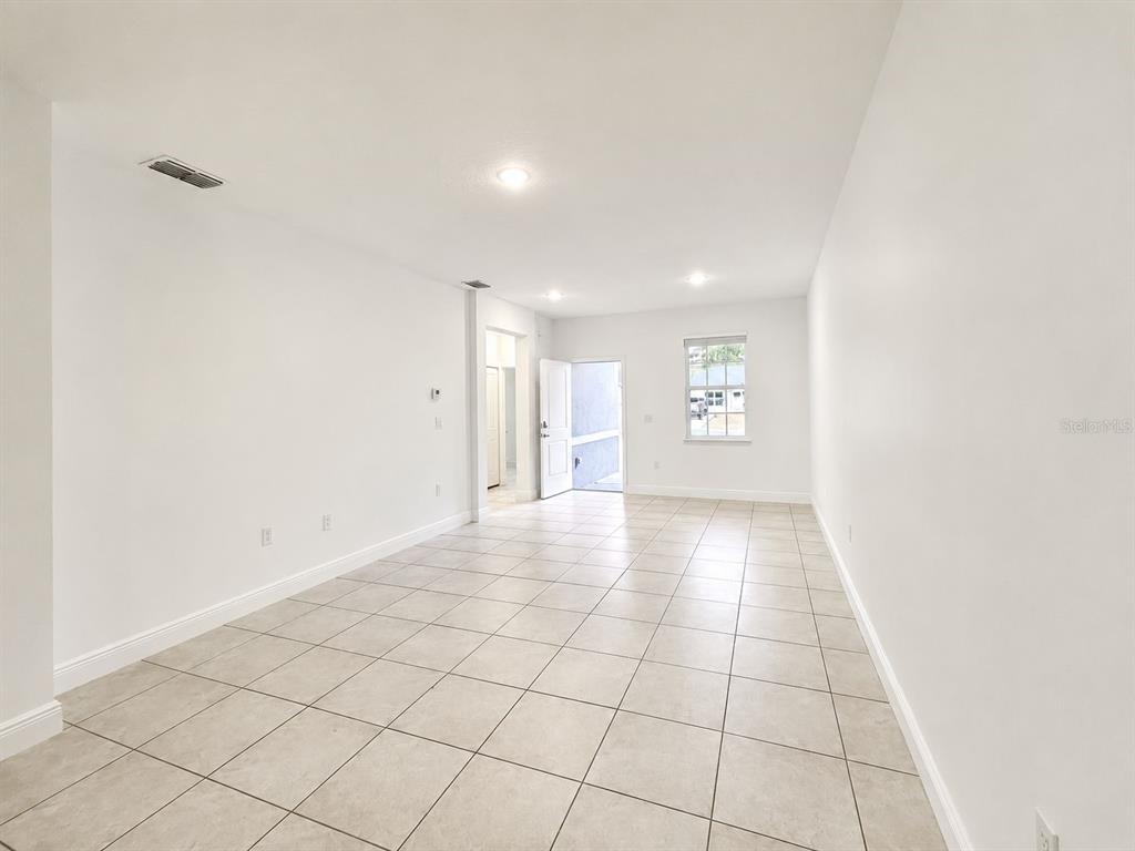 An empty room with white walls, recessed lighting, and light-colored tile flooring — 9130 N MENDOZA WAY UNIT 1, CITRUS SPRINGS, FL