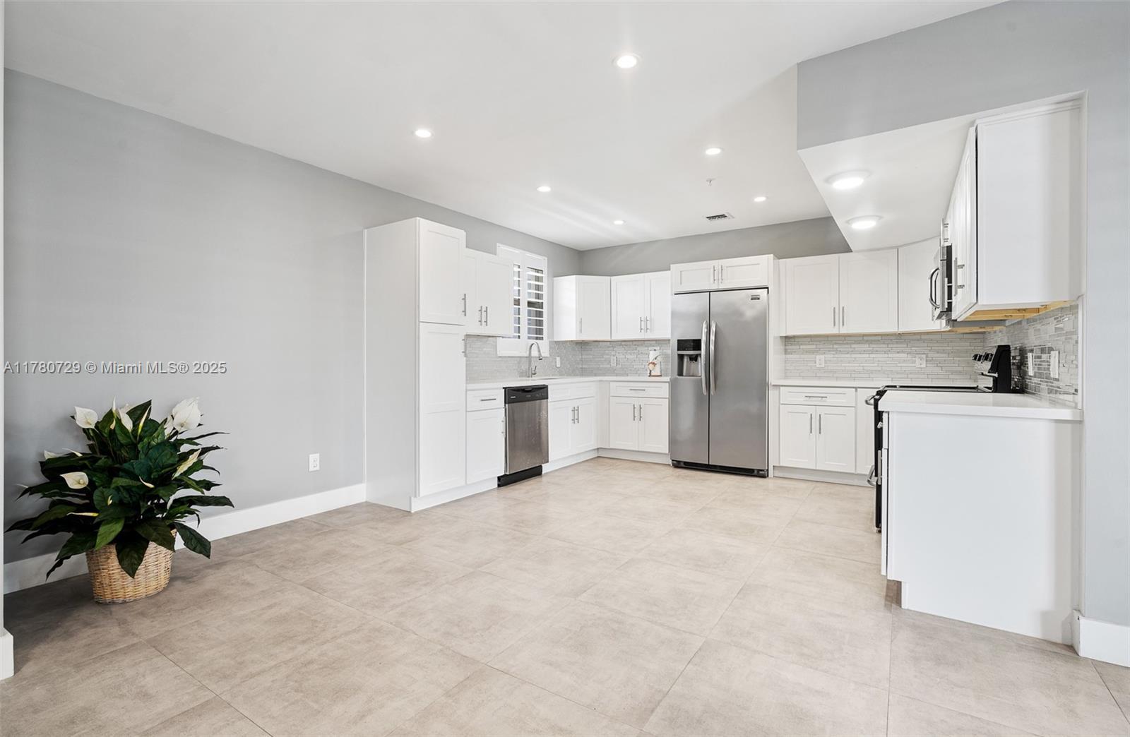 A kitchen features white cabinets, stainless steel appliances, and light gray tile flooring — 555 E Dania Beach Blvd # 4, Dania Beach FL 33004, DANIA BEACH, FL