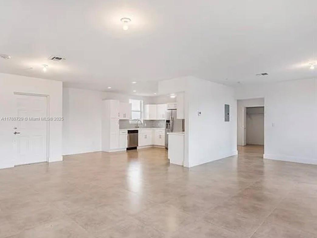 This open-concept living area features white cabinetry, stainless steel appliances, and light-colored tile flooring — 555 E Dania Beach Blvd # 4, Dania Beach FL 33004, DANIA BEACH, FL