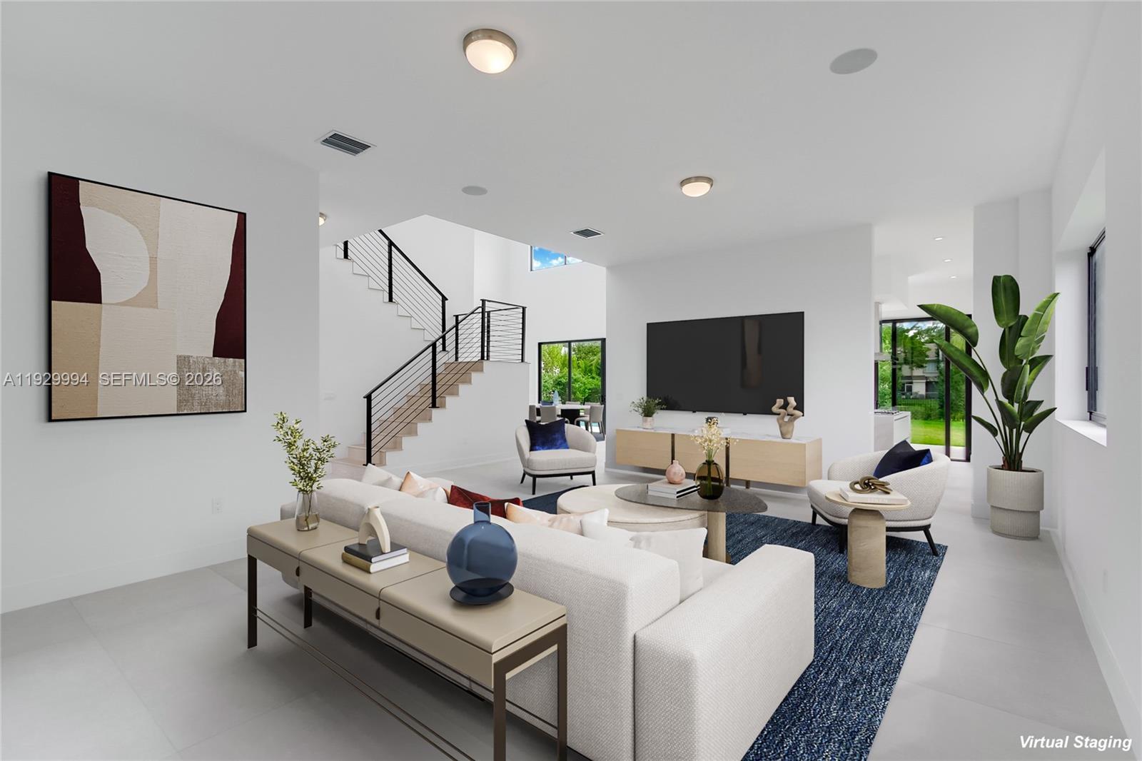 This living room features a modern staircase, white walls, and a large area rug — 16492 S Botaniko Dr S, Weston FL 33326, WESTON, FL
