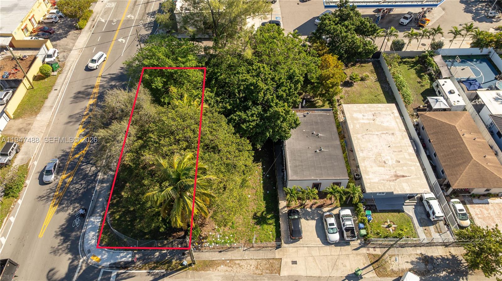 An aerial view shows a vacant, tree-covered rectangular lot outlined in red next to buildings — 2226 NW 46th St, Miami FL 33142, MIAMI, FL