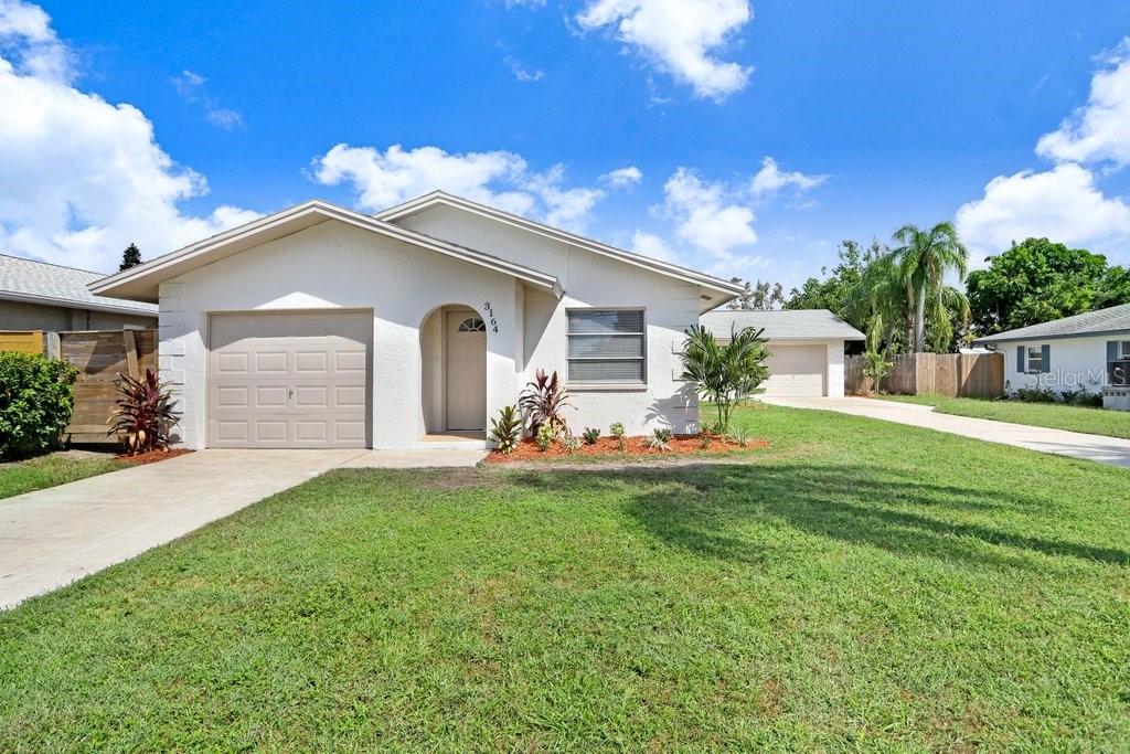 A single-story house with a white exterior, a one-car garage, and a front lawn — 3166 DOWNING STREET, CLEARWATER, FL