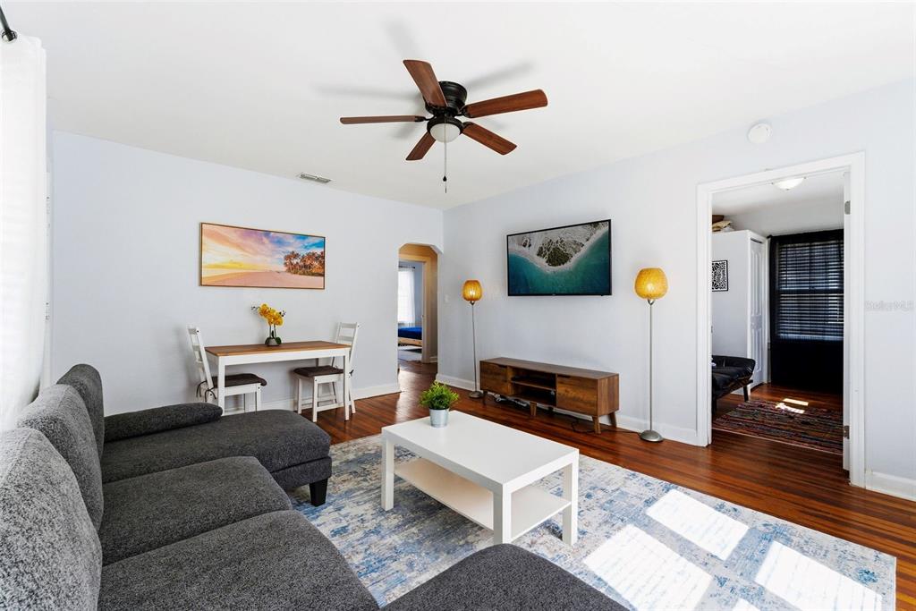A living room features a grey sectional sofa, white coffee table, and a wall-mounted television — 113 AVENUE C SE, WINTER HAVEN, FL