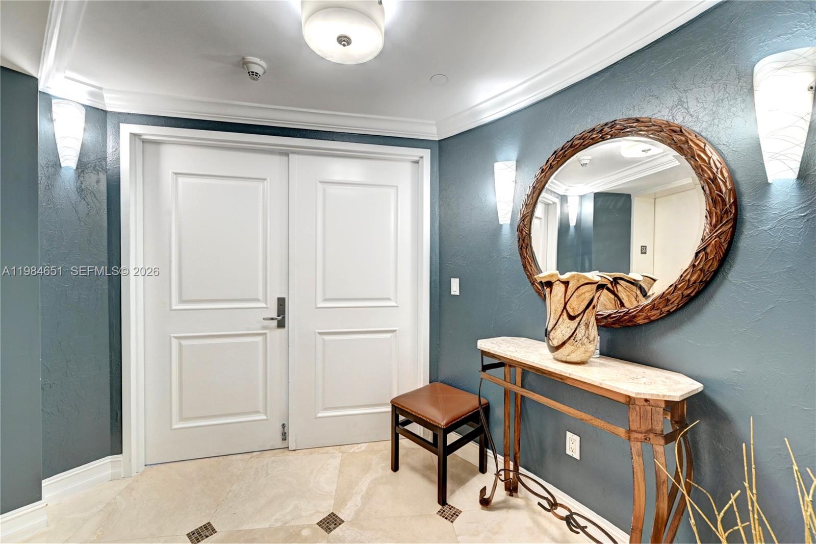 A foyer features a double door, a marble-topped console table, and a round decorative mirror — 3101 S Ocean Dr # 3203, Hollywood FL 33019, HOLLYWOOD, FL