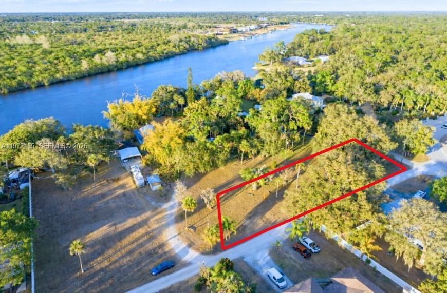 An aerial view shows a rectangular plot of land outlined in red near a river — 2014 Ft Denaud Rd, La Belle FL 33935, LA BELLE, FL