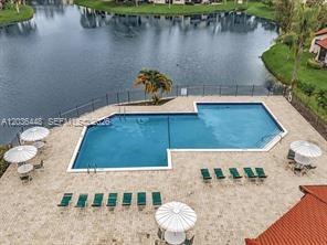 An aerial view shows a swimming pool on a patio overlooking a lake — 9281 W Sunrise Blvd, Plantation FL 33322, PLANTATION, FL