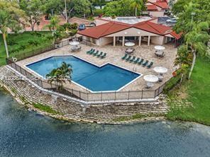 An aerial view shows a swimming pool and patio area next to a lake — 9281 W Sunrise Blvd, Plantation FL 33322, PLANTATION, FL