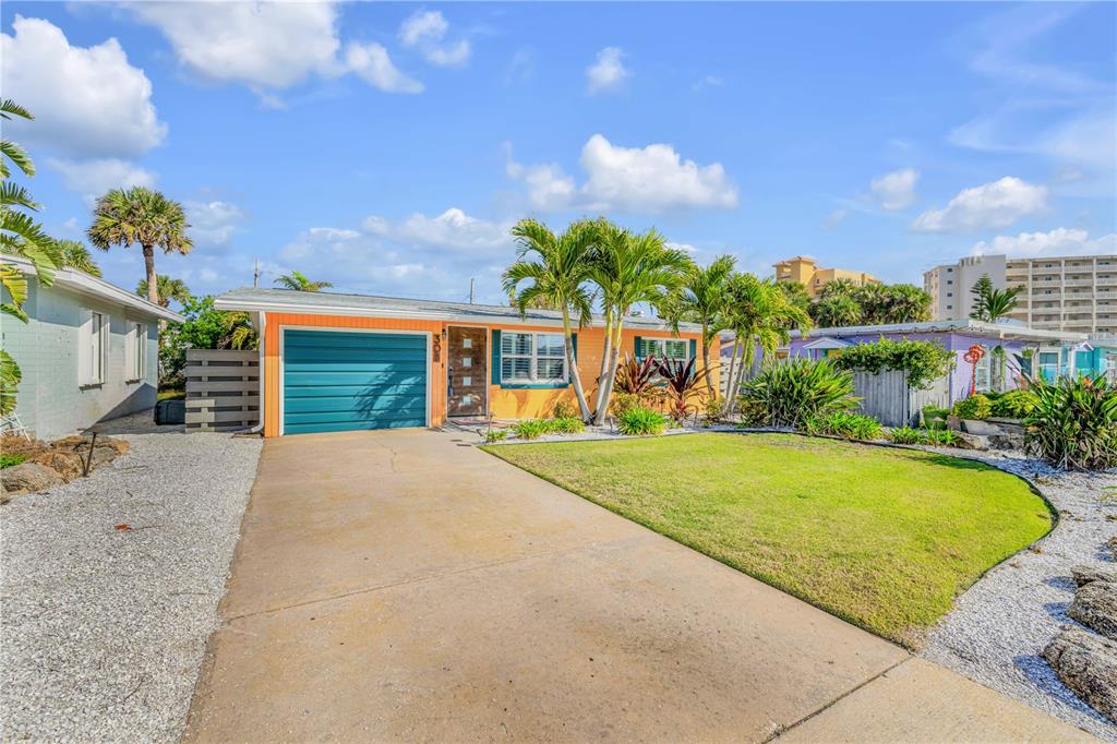 A single-story house with an orange exterior, teal garage door, and a front lawn — 308 NORMANDY AVENUE, NEW SMYRNA BEACH, FL