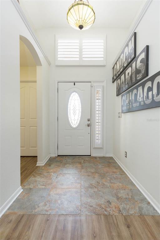 An entryway features a white front door, tile flooring, and wall art of city names — 876 ADDISON DRIVE NE, ST PETERSBURG, FL