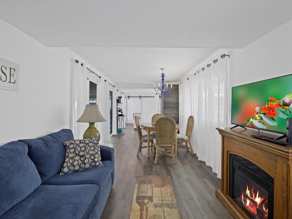A living and dining area with a blue sofa, fireplace, and wicker dining set — 2010 KEPNER DRIVE, HOLIDAY, FL