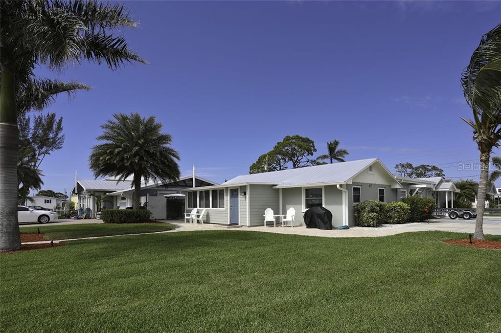 A light green single-story house with a metal roof sits on a grassy lot — 4621 103RD STREET W UNIT B, BRADENTON, FL