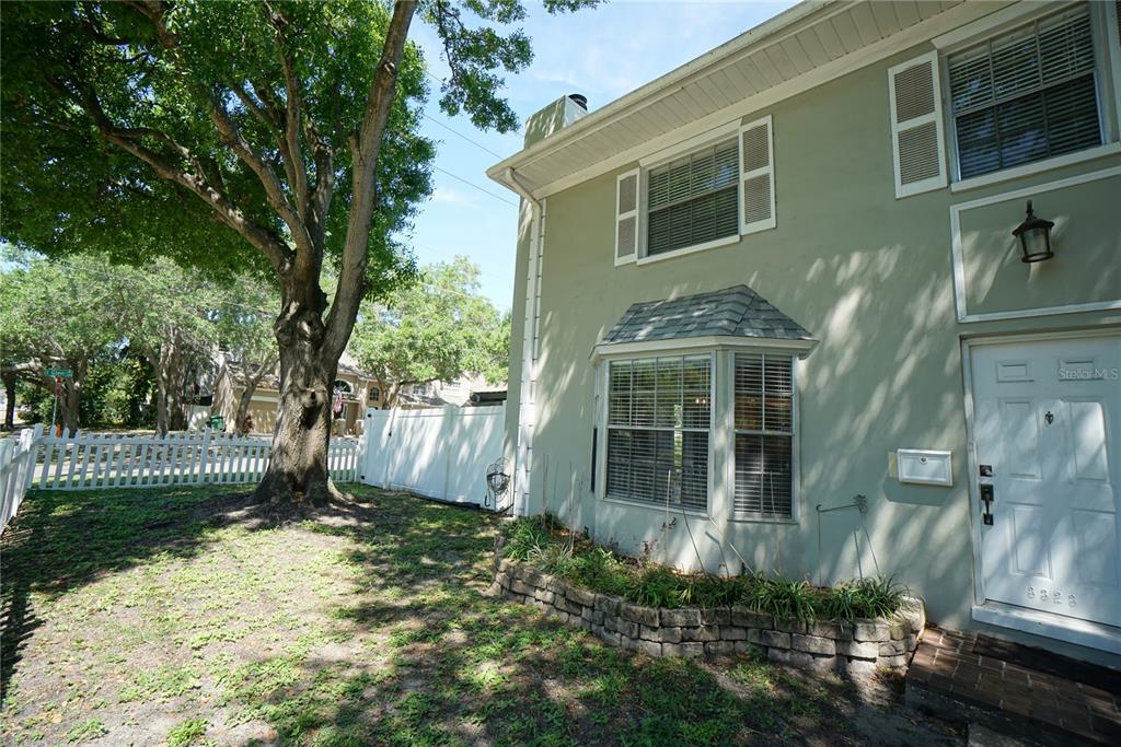 The exterior of a two-story house features a bay window, white shutters, and a tree — 3323 W SWANN AVENUE, TAMPA, FL