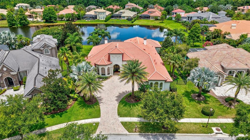 An aerial view shows a large house with a terracotta roof and a paved driveway — 14742 WATERCHASE BOULEVARD, TAMPA, FL