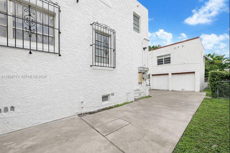 A white stucco building exterior features barred windows and a detached two-car garage — 1736 SW 9th St, Miami FL 33135, MIAMI, FL