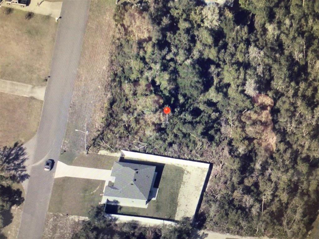 An aerial view shows a house with a fenced backyard adjacent to a wooded area — MARION OAKS DRIVE, OCALA, FL