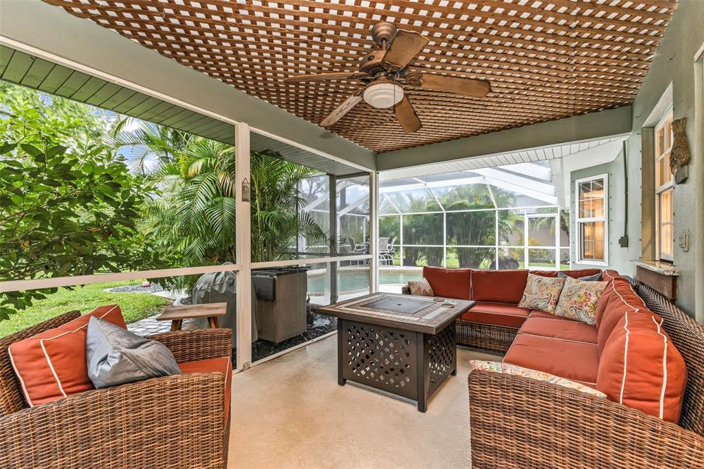A screened-in patio features wicker furniture, a fire pit table, and a wooden lattice ceiling — 73 MANIZAKS AVENUE, PUNTA GORDA, FL