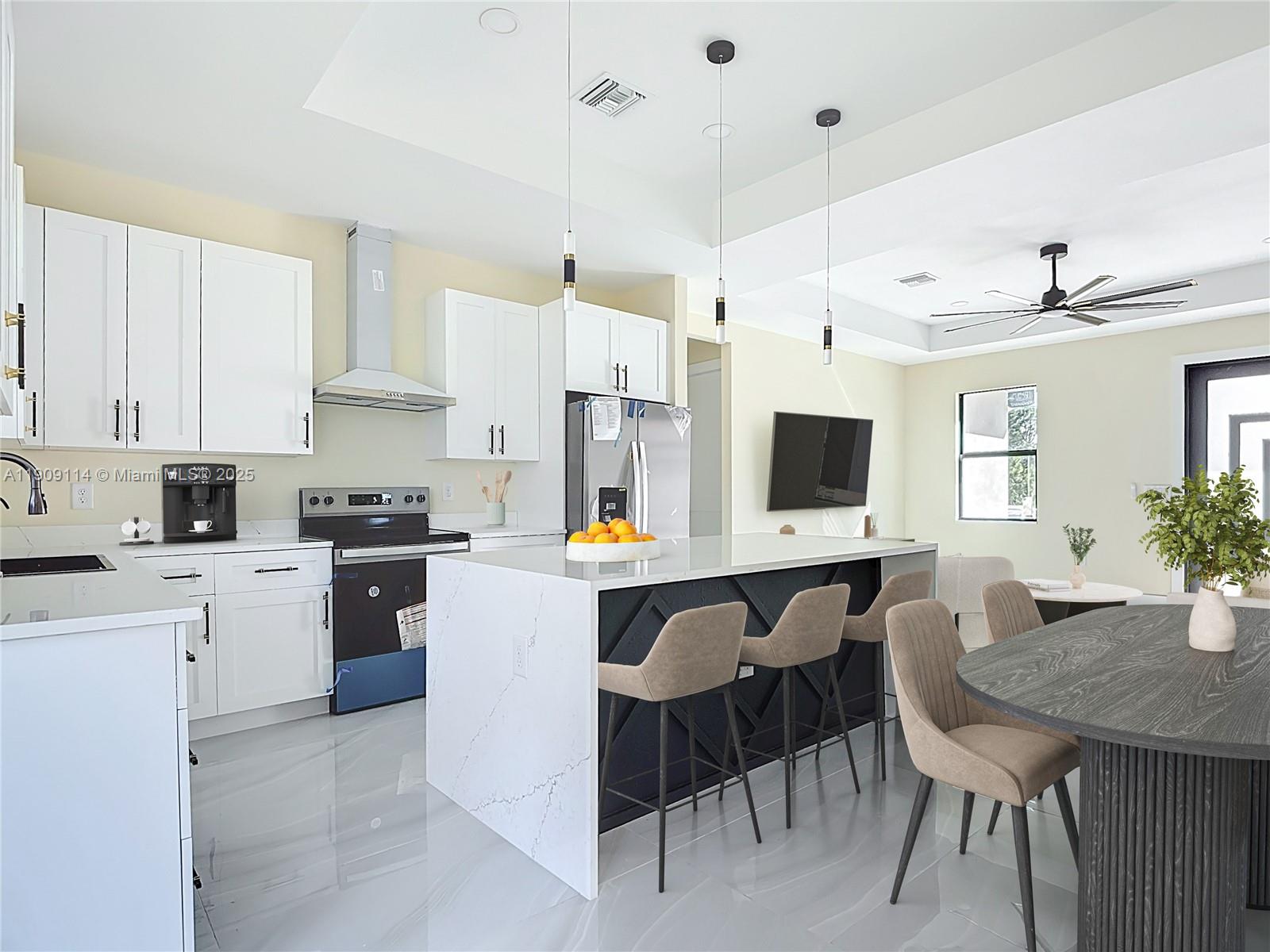 A modern kitchen features white cabinetry, a marble-topped island, and a dark dining table — 3814 9th St SW, Lehigh Acres FL 33976, LEHIGH ACRES, FL