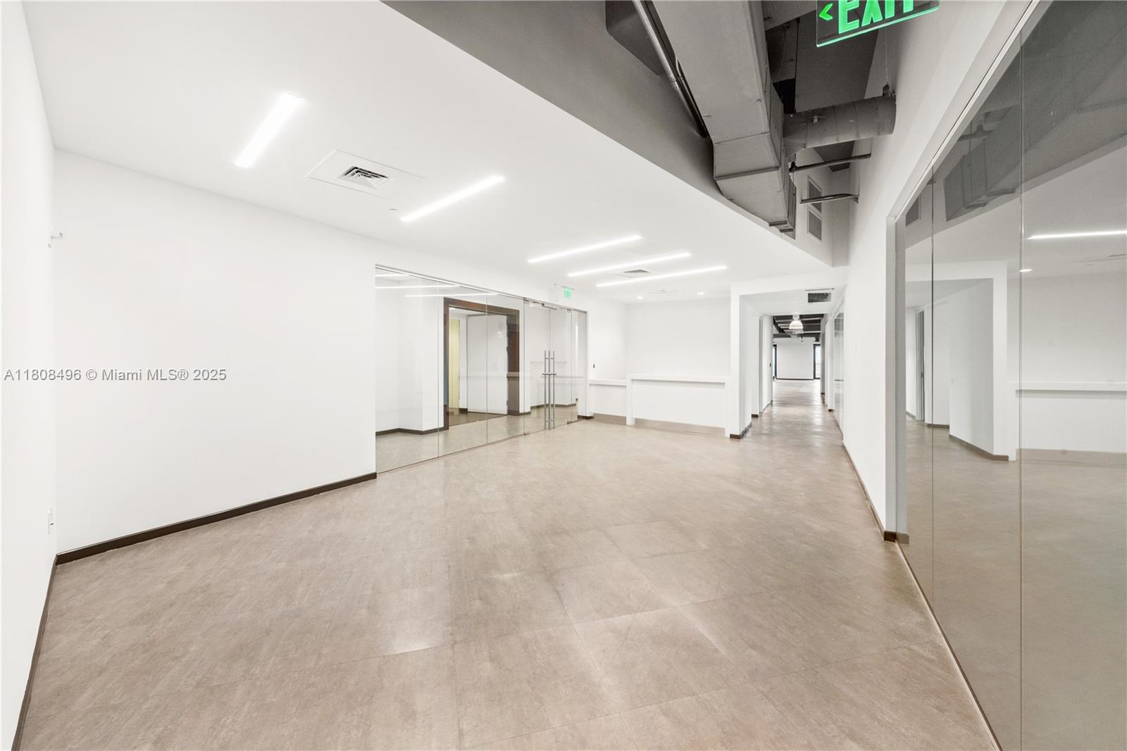 A modern, empty office space features white walls, tile flooring, and glass-walled partitions — 2020 Ponce De Leon Blvd, Coral Gables FL 33134, CORAL GABLES, FL