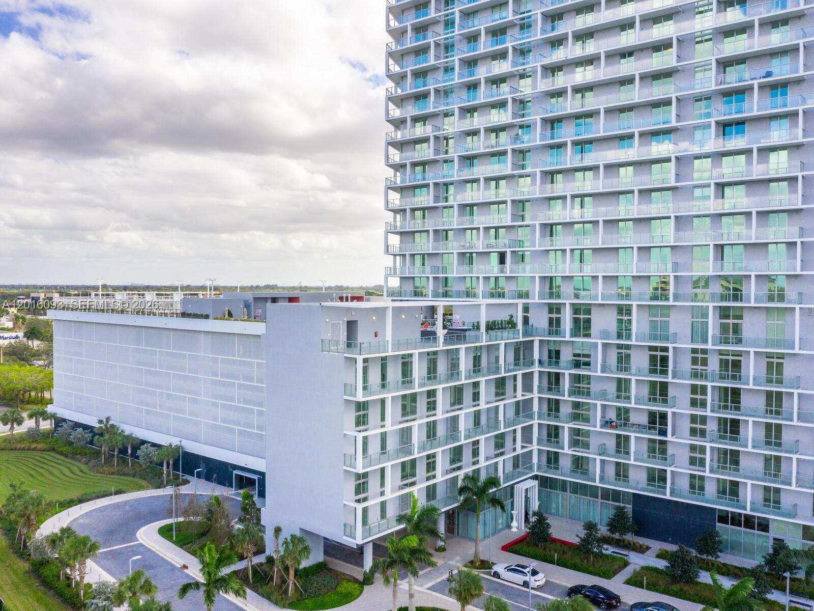 An exterior view of a modern high-rise apartment building with balconies and an attached parking garage — 2000 S Metropica Way # 2007, Sunrise FL 33323, SUNRISE, FL
