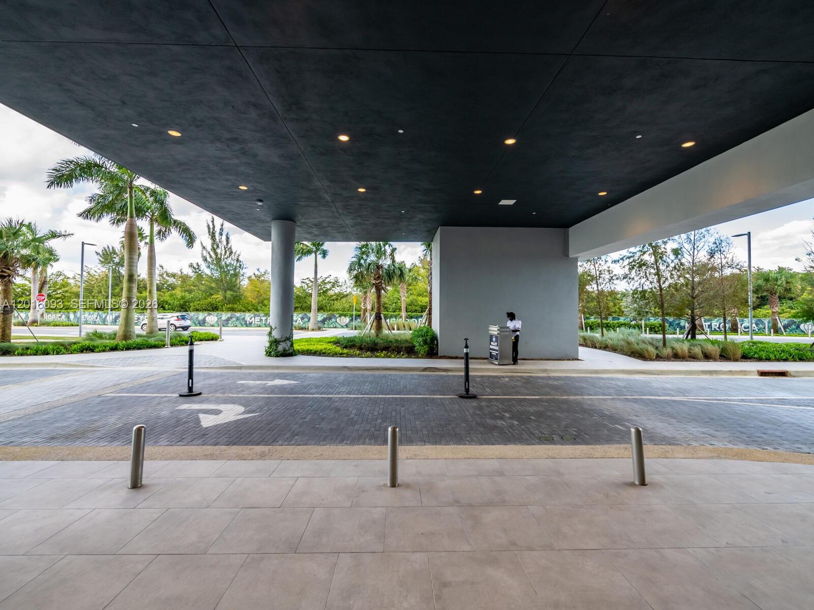 A valet station stands under a large, modern covered entrance with a dark ceiling — 2000 S Metropica Way # 2007, Sunrise FL 33323, SUNRISE, FL
