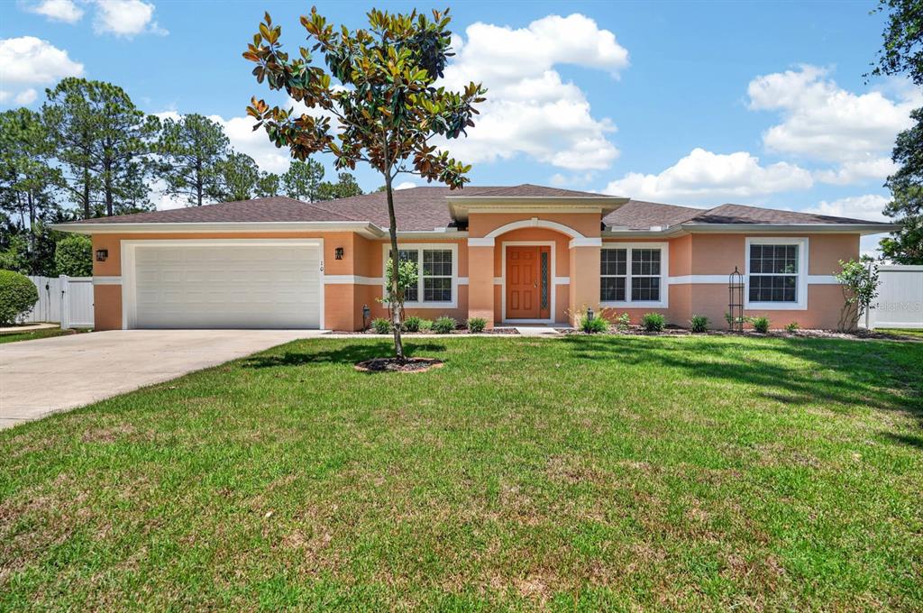A single-story peach-colored house with a two-car garage and a front lawn — 10 PRINCESS MARI PLACE, PALM COAST, FL