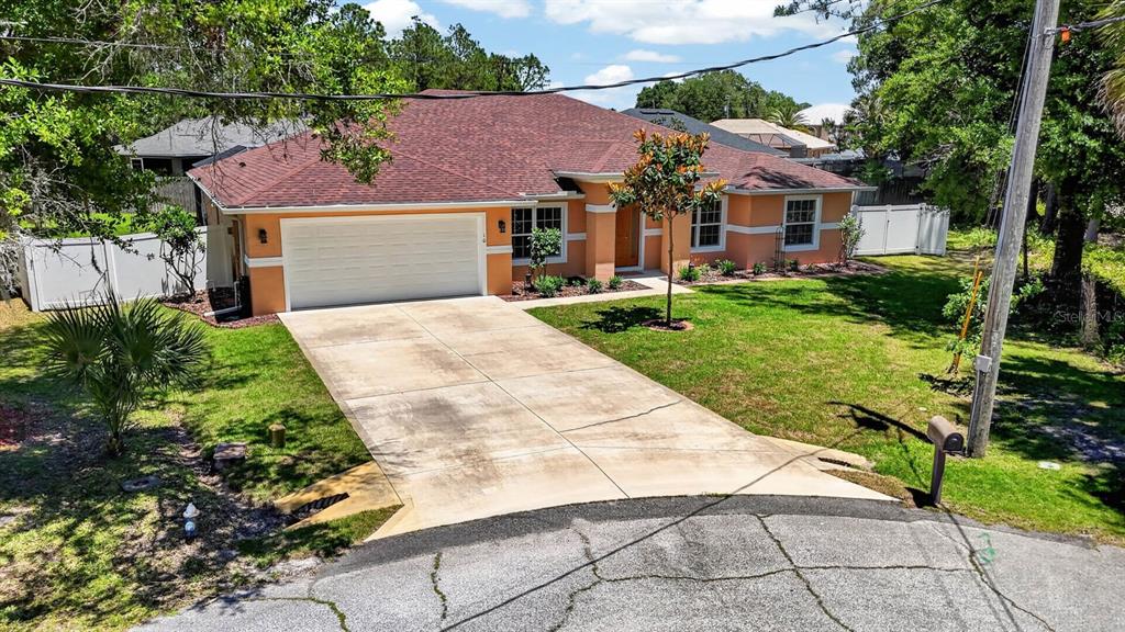 A single-story house with an orange exterior, a two-car garage, and a concrete driveway — 10 PRINCESS MARI PLACE, PALM COAST, FL