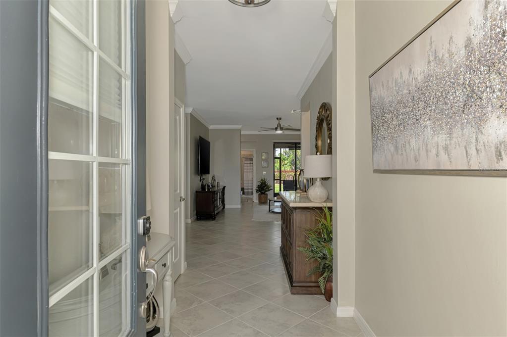 A view from a doorway into a tiled foyer leading to a living area — 15896 HONEYSUCKLE STREET, PORT CHARLOTTE, FL